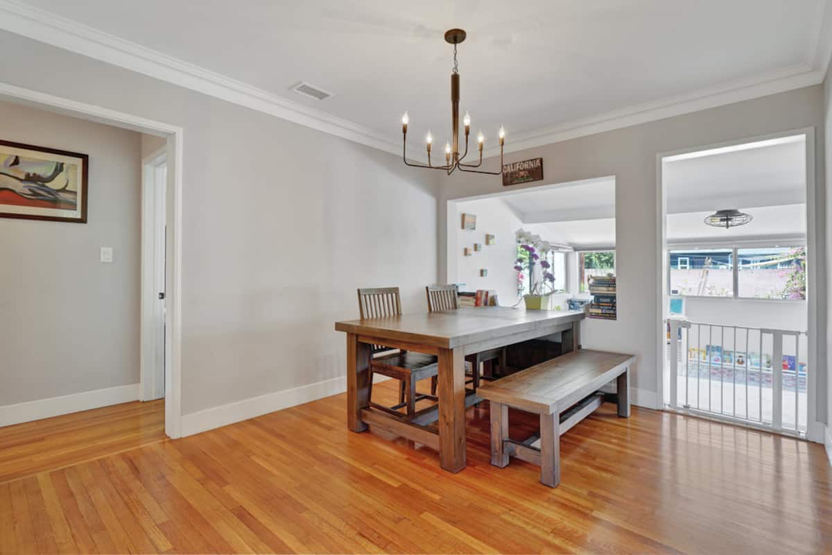 The dining room with a wooden table, benches and chandelier