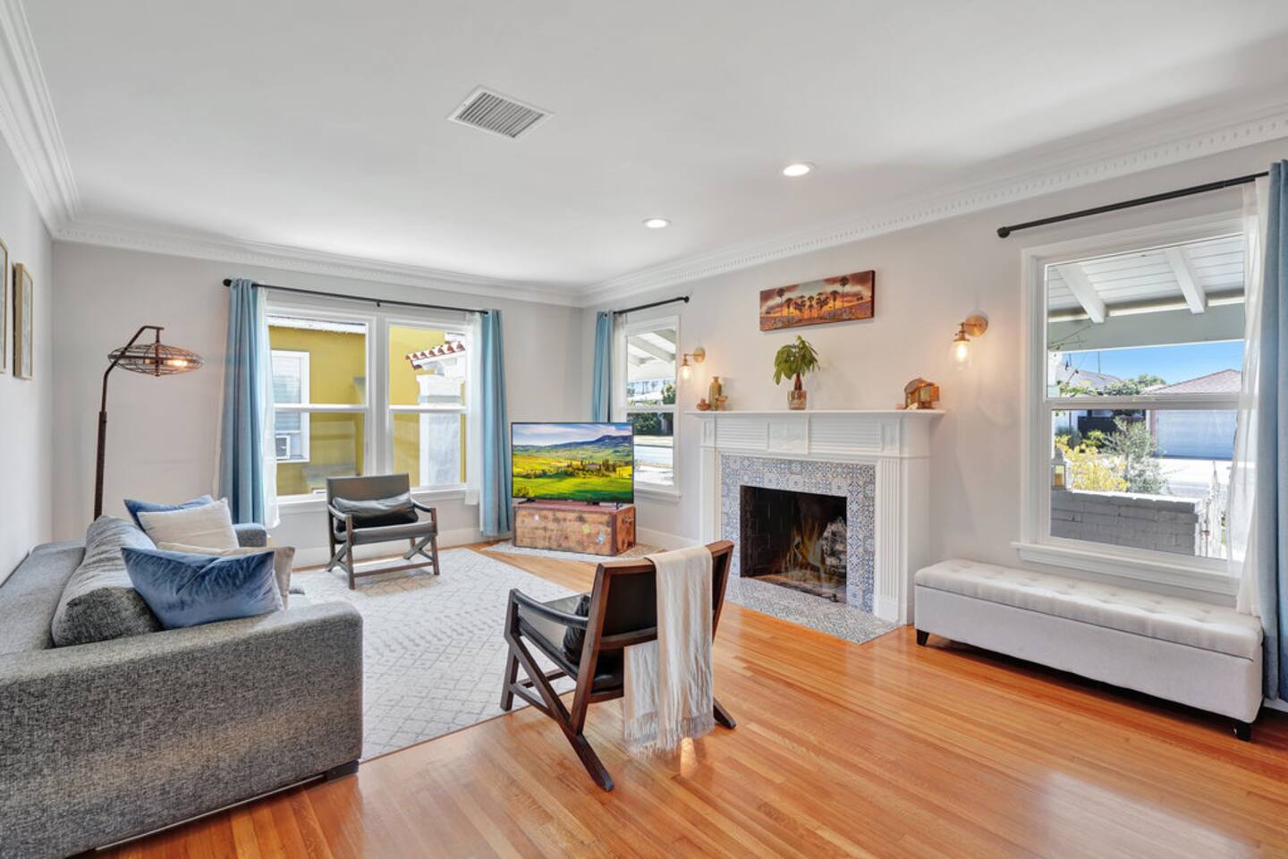 The living room with its tiled fireplace, window bench and warm lamplight