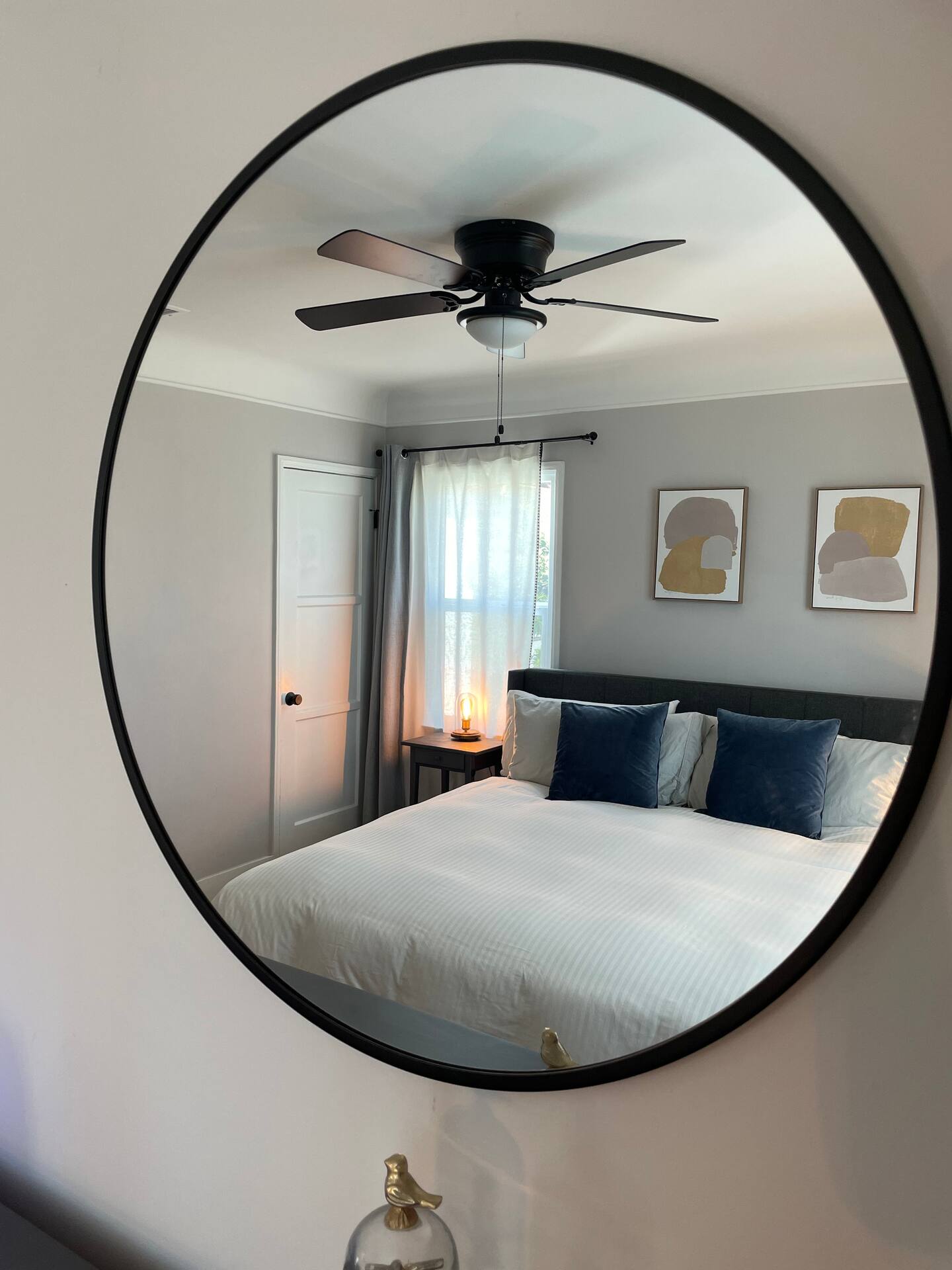 A bedroom reflected in a round mirror